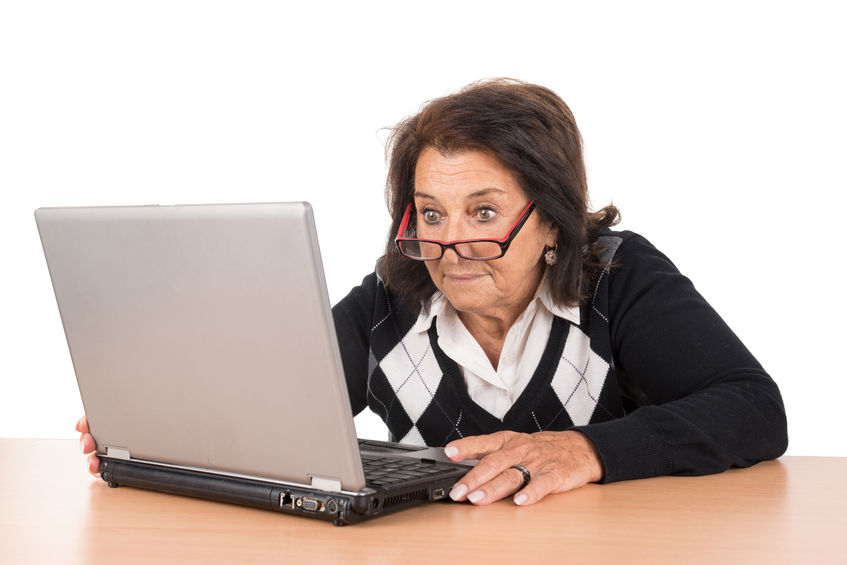 55449884 - surprised beautiful senior woman looking at a laptop isolated in white
